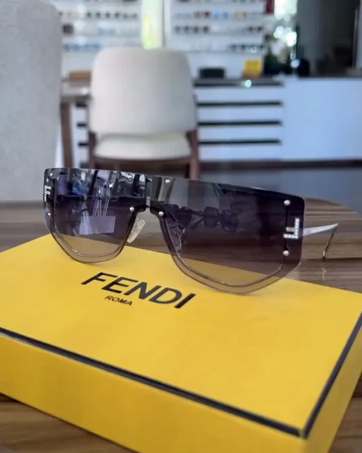 Solaires Fendi posées sur leur boîte jaune, dans la boutique