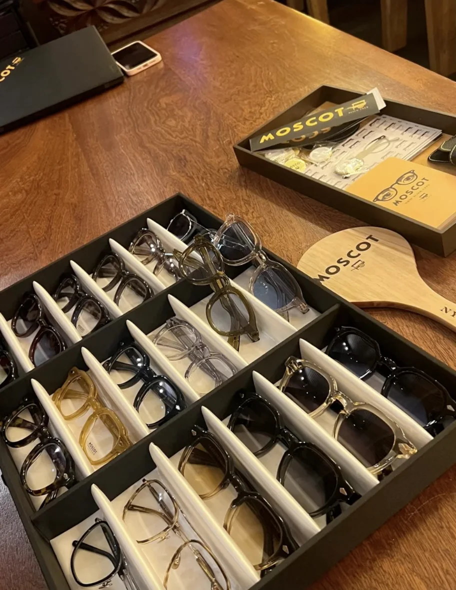 Plateau de montures Moscot dans la boutique, à côté du coffret de la marque